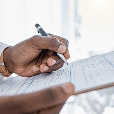 a hand filling out a dental insurance form